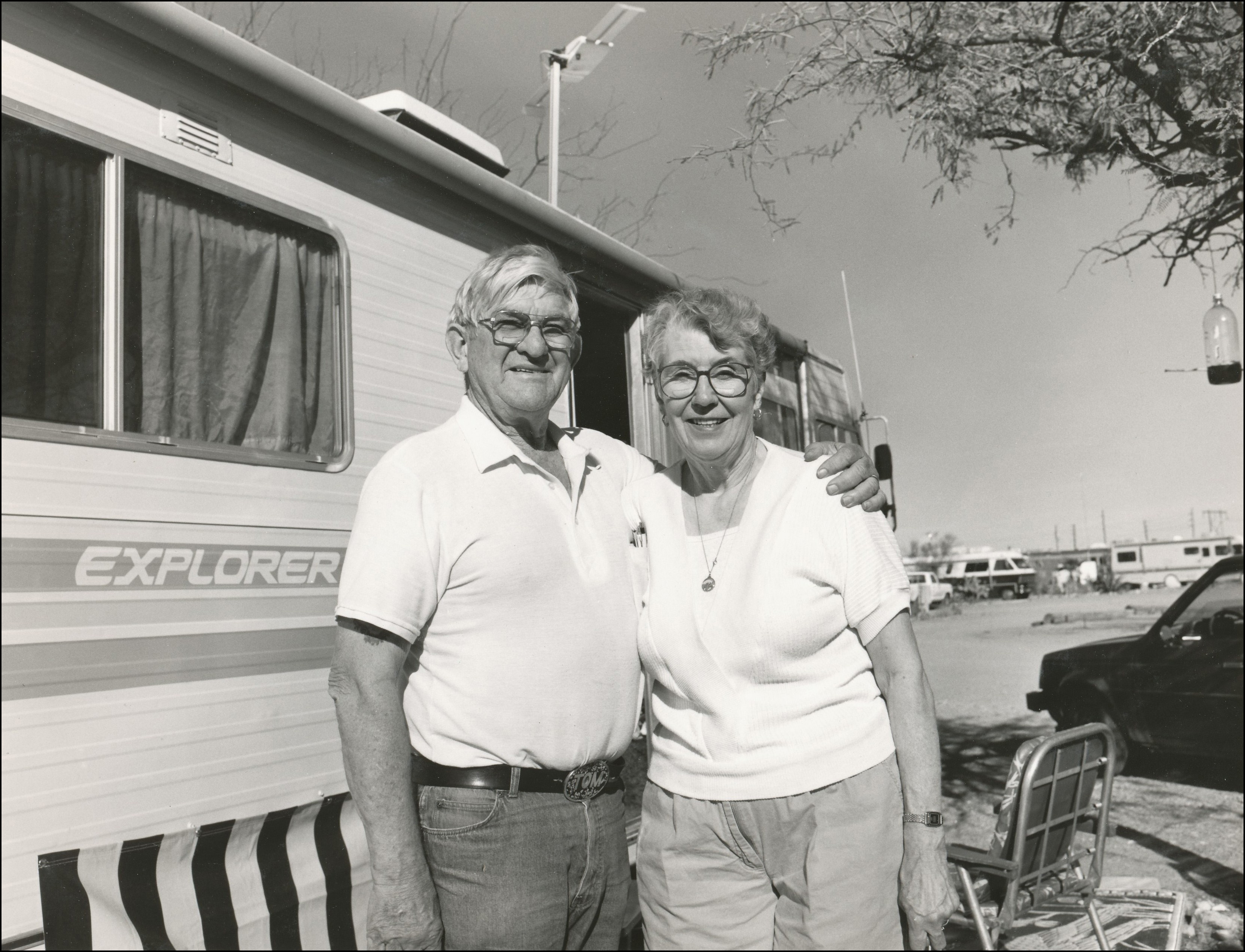 Older couple standing in front of their camper